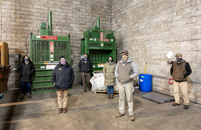 A group of Bell's folks stands in front the of the industrial equipment that will help keep plastic out of landfills.