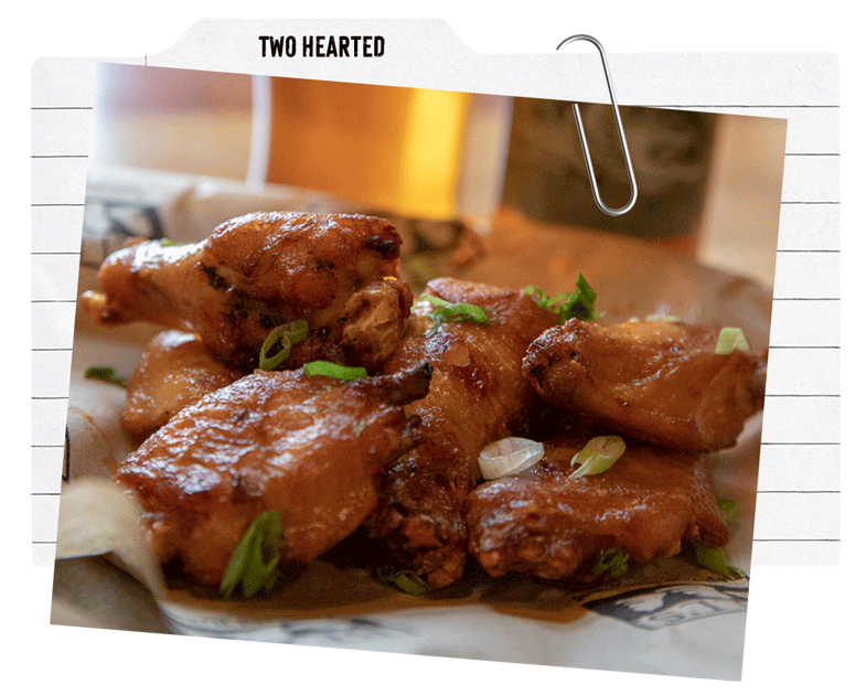 A plate of chicken wings tossed in a two hearted based sauce