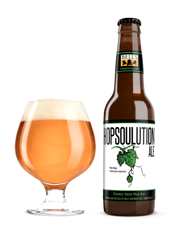 a full snifter glass sitting next to a bottle of Hopsoulution Ale