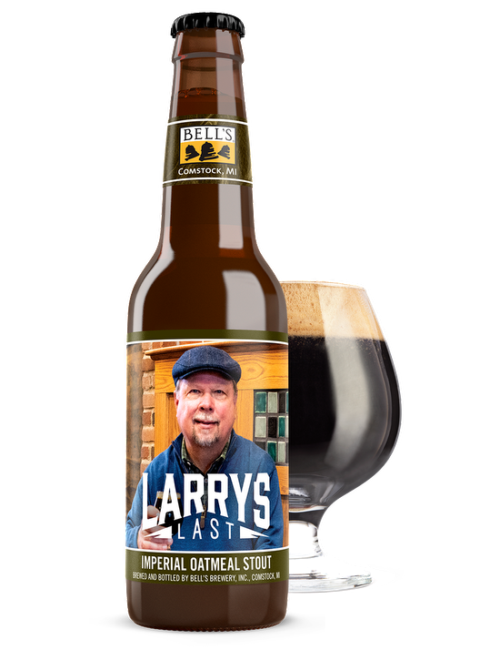 A bottle of Larry's Last sitting in front of a full snifter glass