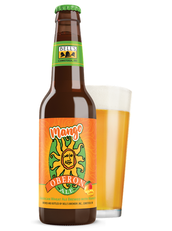 A bottle of Mango Oberon Ale sitting in front of a full glass