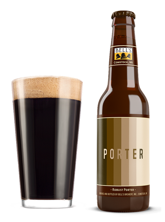 A full glass sitting in front of a bottle of Porter