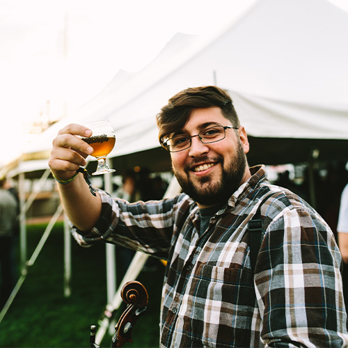 a violinist drinks a glass of beer
