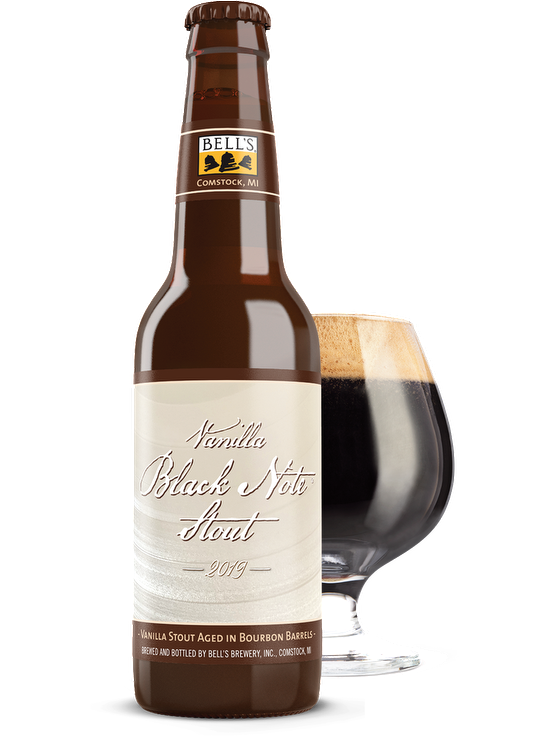 A bottle of Vanilla Black Note Stout sitting in front of a full snifter glass