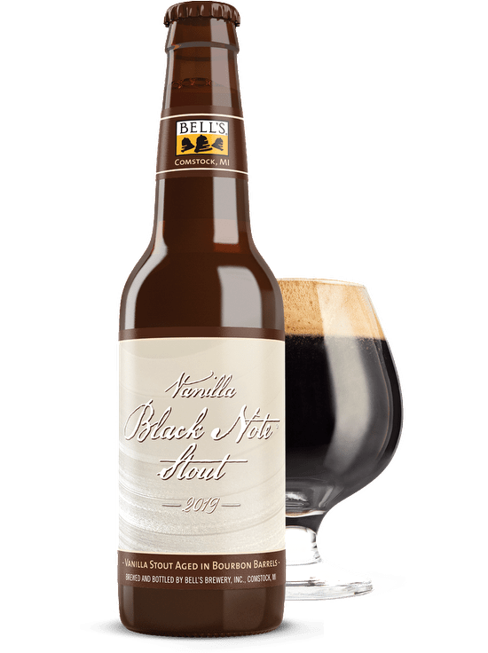 A bottle of Vanilla Black Note Stout sitting in front of a full snifter glass