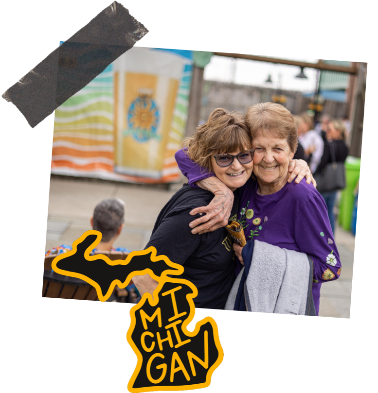 Two women hugging in front of an oberon sign