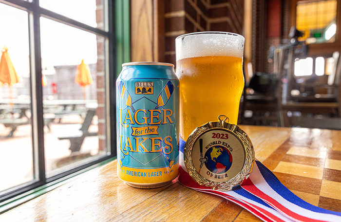12 oz can of Lager for the Lakes next to pint glass with liquid and the award medal.