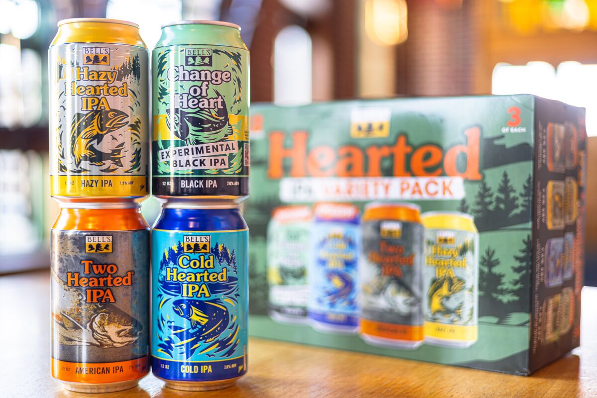 "Four cans of Bell's Brewery beers are displayed in front of their Hearted Variety Pack box. From left to right, the cans are labeled 'Two Hearted IPA,' 'Hazy Hearted IPA,' and 'Cold Hearted IPA,' and Change of Heart IPA. Each with distinctive, colorful artwork featuring fish designs."