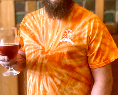 Short sleeve, orange tie-dye t-shirt with the oberon logo in white on the left breast