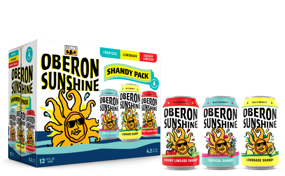 Case of Oberon Sunshine Shandy with three individual cans next to it.