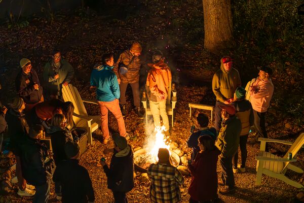 People surrounding a bonfire at night